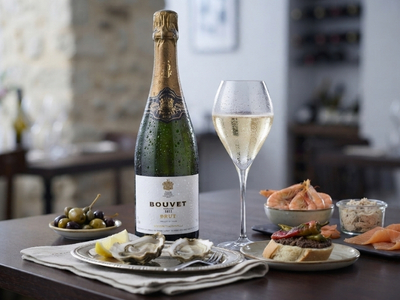 Crémant neben Essen auf Tisch